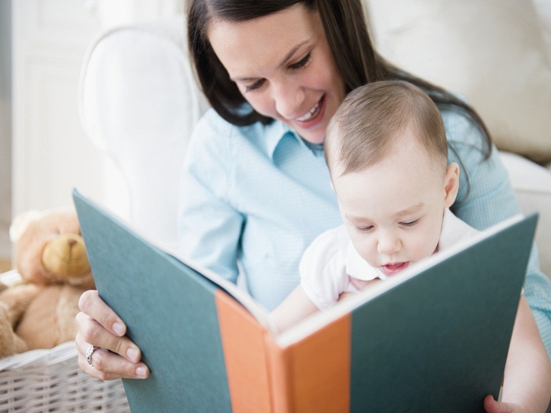 Mother with daughter (6-11 months) reading book